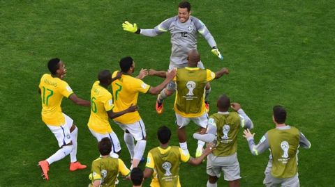 BELO HORIZONTE, BRAZIL - JUNE 28: Julio Cesar of Brazil celebrates with teammates after defeating Chile in a penalty shootout during the 2014 FIFA World Cup Brazil round of 16 match between Brazil and Chile at Estadio Mineirao on June 28, 2014 in Belo Horizonte, Brazil.  (Photo by Francois Xavier Marit - Pool/Getty Images)