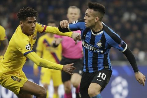 Inter Milan's Lautaro Martinez, right, fights for the ball with Barcelona's Jean-Clair Todibo during the Champions League, group F soccer match between Inter Milan and F.C. Barcelona, at the San Siro stadium in Milan, Italy, Tuesday, Dec. 10, 2019. (AP Photo/Luca Bruno)