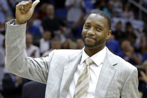 FILe - In this Nov. 1, 2013, file phioto, former Orlando Magic player Tracy McGrady gives the thumbs up to fans as he was honored in a ceremony commemorating the Magic's 25th season during the first half of an NBA basketball game against the New Orleans Pelicans,  in Orlando, Fla.  Former All-Star Tracy McGrady is joining ESPN as an analyst and will make regular appearances on its new daily NBA show. (AP Photo/John Raoux, File)