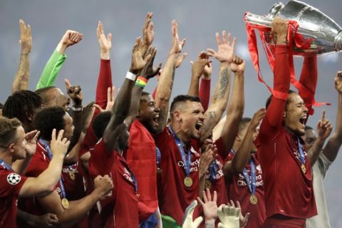 Liverpool's Virgil van Dijk lifts the trophy as celebrates with his teammates after winning the Champions League final soccer match between Tottenham Hotspur and Liverpool at the Wanda Metropolitano Stadium in Madrid, Sunday, June 2, 2019. Liverpool won 2-0. (AP Photo/Felipe Dana)