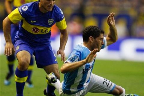 Boca Juniors' Diego Rivero, left, fights for the ball with Racing Club's Lucas Licht during an Argentine league soccer match in Buenos Aires, Argentina, Sunday Nov. 20, 2011. (AP Photo/Natacha Pisarenko)