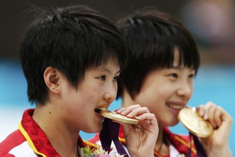 China's Chen Ruolin and Wang Hao (R) pose with their gold medals after winning the women's synchronised 10m platform final at the London 2012 Olympic Games at the Aquatics Centre July 31, 2012. REUTERS/Jorge Silva (BRITAIN  - Tags: SPORT OLYMPICS SPORT DIVING)  