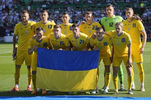 Οι παίκτες της εθνικής Ουκρανίας κρατώντας τη σημαία της χώρας