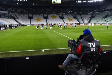 FILE - In this Sunday, March 8, 2020. filer, players warm up in the empty Allianz stadium, prior to the Serie A soccer match between Juventus and Inter Milan, in Turin, Italy. The Italian soccer players' association rejected a proposal from Serie A clubs Monday to reduce salaries by a third if the season does not resume as "unmanageable." The guideline austerity measure was agreed on by 19 of the 20 clubs, the Italian league announced, with Juventus not included because it already finalized a deal with its players to relieve financial pressure on the eight-time defending champion amid the coronavirus pandemic. (Marco Alpozzi/LaPresse via AP, File)