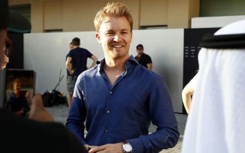 Former Formula One world champion Nico Rosberg, center, smiles as he visits the paddock at the Yas Marina racetrack in Abu Dhabi, United Arab Emirates, Saturday, Nov. 25, 2017. The Emirates Formula One Grand Prix will take place on Sunday. (AP Photo/Hassan Ammar)