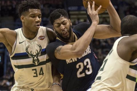 New Orleans Pelicans forward Anthony Davis, center, is defend by Milwaukee Bucks forward Giannis Antetokounmpo, left, and Khris Middleton,right, during the first half of an NBA basketball game Sunday, Feb. 25, 2018, in Milwaukee. (AP Photo/Darren Hauck)