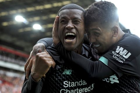 Liverpool's Georginio Wijnaldum, left, celebrates with Liverpool's Roberto Firmino after scoring his side's opening goal during the English Premier League soccer match between Sheffield United and Liverpool at Bramall Lane in Sheffield, England, Saturday, Sept. 28, 2019. (AP Photo/Rui Vieira)