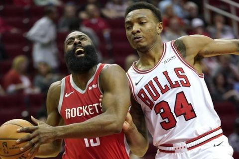 Houston Rockets' James Harden, left, drive toward the basket as Chicago Bulls' Wendell Carter Jr. (34) defends during the first half of an NBA basketball game Saturday, Dec. 1, 2018, in Houston. (AP Photo/David J. Phillip)