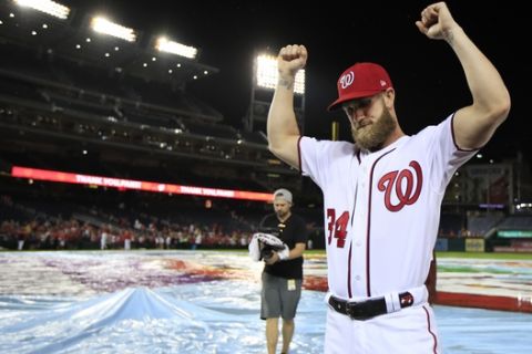 Washington Nationals Bryce Harper (34) bows his head and raise his arms with clenched fists as the Nationals celebrate and bid goodbye to their fans ending their last home game of the season with a 9-3 rain delayed win against the Miami Marlins in Washington, Wednesday, Sept. 26, 2018. (AP Photo/Manuel Balce Ceneta)