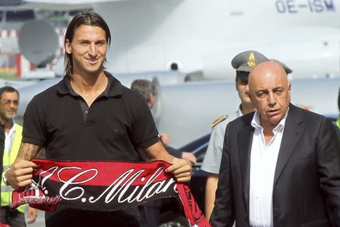 Swedish soccer player Zlatan Ibrahimovic holds an AC Milan scarf next to AC Milan's Vice President Adriano Galliani after arriving from Barcelona at Linate airport in Milan August 29, 2010. AC Milan reached agreement with Barcelona on Saturday to bring former Inter Milan striker Ibrahimovic back to Italy in a move the club hope will ignite their title chances. REUTERS/Alessandro Garofalo (ITALY - Tags: SPORT SOCCER)