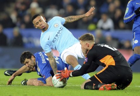 Manchester City's Gabriel Jesus, centre, is tackled by Leicester's Aleksandar Dragovic, left, during the League Cup Quarter Final soccer match between Leicester City and Manchester City at the King Power Stadium in Leicester, England, Tuesday, Dec. 19, 2017. (AP Photo/Rui Vieira)