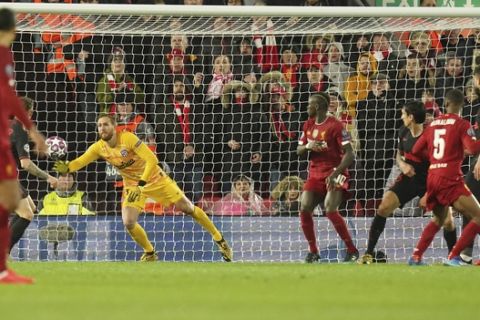 Atletico Madrid's goalkeeper Jan Oblak fails to save the ball as Liverpool's Georginio Wijnaldum, second right, scores his side's opening goal during a second leg, round of 16, Champions League soccer match between Liverpool and Atletico Madrid at Anfield stadium in Liverpool, England, Wednesday, March 11, 2020. (AP Photo/Jon Super)