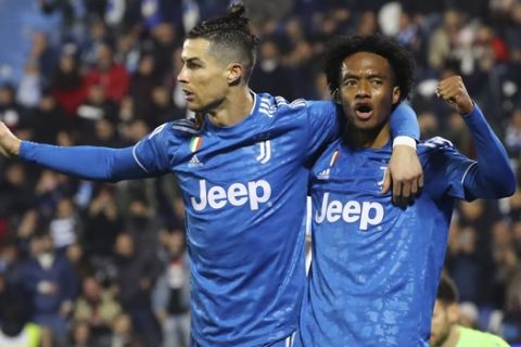 Juventus' Cristiano Ronaldo, left, celebrates with teammate Juan Cuadrado after scoring his side's first goal, during an Italian Serie A soccer match between Spal and Juventus at the Paolo Mazza stadium in Ferrara, Italy, Saturday, Feb. 22, 2020. (Filippo Rubin/LaPresse via AP)