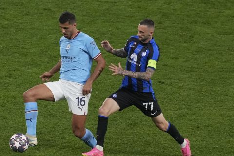 Manchester City's Rodrigo, left, and Inter Milan's Marcelo Brozovic go for the ball during the Champions League final soccer match between Manchester City and Inter Milan at the Ataturk Olympic Stadium in Istanbul, Turkey, Saturday, June 10, 2023. (AP Photo/Thanassis Stavrakis)