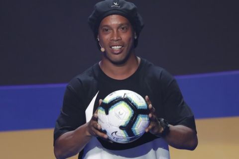 Brazil's Ronaldinho Gaucho shows the official ball during the draw for the 2019 Copa America soccer tournament in Rio de Janeiro, Brazil, Thursday, Jan. 24, 2019. Brazil will host the continental soccer tournament in June and July. (AP Photo/Andre Penner)