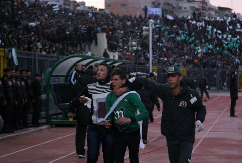 A wounded Egyptian fan of Al-Masry is escorted by a medic and a friend following clashes between rival football fans after a football match between Al-Masry and Al-Ahly in Port Said on February 1, 2012. At least 74 people were killed and hundreds injured when rival fans clashed after the football match, highlighting a security vacuum in post-revolution Egypt. AFP PHOTO/STR (Photo credit should read STR/AFP/Getty Images)