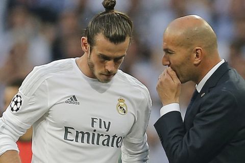 Real Madrid's headcoach Zinedine Zidane, speaks to Real Madrid's Gareth Bale, left, during the Champions League semifinal second leg soccer match between Real Madrid and Manchester City at the Santiago Bernabeu stadium in Madrid, Wednesday May 4, 2016. (AP Photo/Paul White)