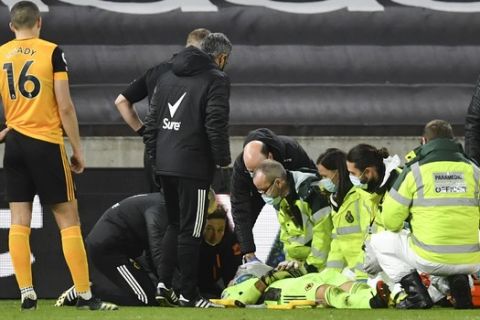 Medical staff attend to Wolverhampton Wanderers' goalkeeper Rui Patricio during the English Premier League soccer match between Wolverhampton Wanderers and Liverpool at Molineux Stadium in Wolverhampton, England, Monday, March. 15, 2021. (AP Photo/Paul Ellis,Pool)