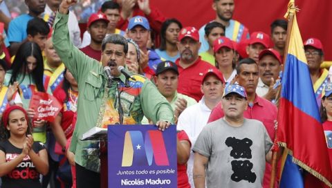 Argentina's former star player Diego Armando Maradona, right, listens to Venezuela's President Nicolas Maduro speaking during his closing campaign rally in Caracas, Venezuela, Thursday, May 17, 2018. Maduro is seeking a new six-year mandate and despite crippling hyperinflation and widespread shortages of food and medicine, he is widely expected to win it in next May 20 election, that opponents have denounced as a fraud and have been condemned by much of the international community. (AP Photo/Ariana Cubillos)