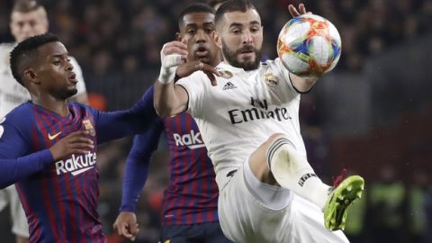 Real forward Karim Benzema, right, controls the ball as Barcelona defender Nelson Semedo is seen left, during the Copa del Rey semifinal first leg soccer match between FC Barcelona and Real Madrid at the Camp Nou stadium in Barcelona, Spain, Wednesday Feb. 6, 2019. (AP Photo/Emilio Morenatti)