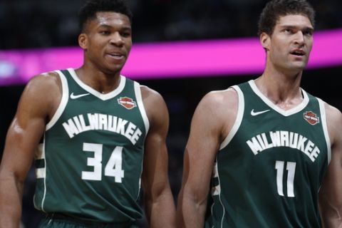 Milwaukee Bucks forward Giannis Antetokounmpo, left, heads to the bench with center Brook Lopez in the first half of an NBA basketball game against the Denver Nuggets Sunday, Nov. 11, 2018, in Denver. (AP Photo/David Zalubowski)