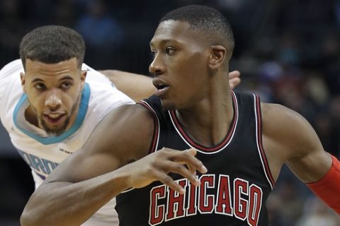 Chicago Bulls' Kris Dunn, front, dribbles past Charlotte Hornets' Michael Carter-Williams, back, during the second half of an NBA basketball game in Charlotte, N.C., Tuesday, Feb. 27, 2018. The Hornets won 118-103. (AP Photo/Bob Leverone)