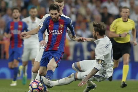 Barcelona's Lionel Messi is fouled by Real Madrid's Sergio Ramos during a Spanish La Liga soccer match between Real Madrid and Barcelona, dubbed 'el clasico', at the Santiago Bernabeu stadium in Madrid, Spain, Sunday, April 23, 2017. (AP Photo/Daniel Ochoa de Olza)