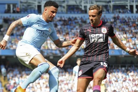 Manchester City's Kyle Walker, left, and Huddersfield's Chris Lowe vie for the ball during the English Premier League soccer match between Manchester City and Huddersfield Town at Etihad stadium in Manchester, England, Sunday, May 6, 2018. (AP Photo/Rui Vieira)