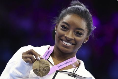 United States' Simone Biles poses with her gold medal on the floor exercise during the apparatus finals at the Artistic Gymnastics World Championships in Antwerp, Belgium, Sunday, Oct. 8, 2023. (AP Photo/Geert vanden Wijngaert)