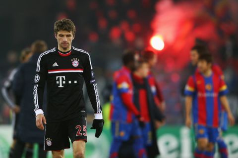 BASEL, SWITZERLAND - FEBRUARY 22:  Thomas Mueller of Muenchen reacts as players of Basel celebrate after the UEFA Champions League Round of 16 first leg match between FC Basel 1893 and FC Bayern Muenchen at St. Jakob-Park on February 22, 2012 in Basel, Switzerland.  (Photo by Alex Grimm/Bongarts/Getty Images)