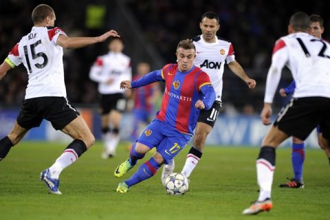 FC Basel's midfielder Xherdan Shaqiri (C) controls the ball between Manchester United's Serbian defender Nemanja Vidic (L) Welsh midfielder Ryan Giggs and English defender Chris Smalling (R) during their UEFA Champions League group C football match on December 7, 2011  in Basel.  AFP PHOTO / FABRICE COFFRINI (Photo credit should read FABRICE COFFRINI/AFP/Getty Images)
