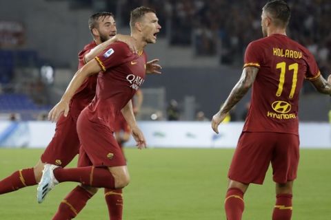 Roma's Edin Dzeko, center, celebrates with his teammates after scoring his side's second goal during the Serie A soccer match between Roma and Genoa at the Rome Olympic stadium, Sunday, Aug. 25, 2019. (AP Photo/Alessandra Tarantino)