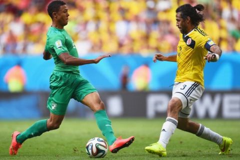 BRASILIA, BRAZIL - JUNE 19: Mathis Bolly of Cote D'Ivoire takes on Mario Yepes of Colombia during the 2014 FIFA World Cup Brazil Group C match between Colombia and Cote D'Ivoire at Estadio Nacional on June 19, 2014 in Brasilia, Brazil.  (Photo by Dennis Grombkowski - FIFA/FIFA via Getty Images)