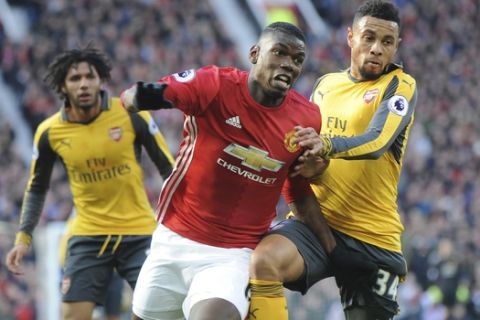 Manchester United's Paul Pogba, left, and Arsenal's Francis Coquelin battle for the ball during the English Premier League soccer match between Manchester United and Arsenal at Old Trafford in Manchester, England, Saturday, Nov. 19, 2016. (AP Photo/Rui Vieira)