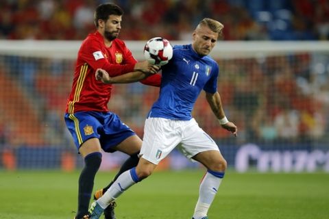 Spain's Gerard Pique, left, fights for the ball with Italy's Ciro Immobile during the World Cup Group G qualifying soccer match between Spain and Italy at the Santiago Bernabeu Stadium in Madrid, Saturday Sept. 2, 2017. (AP Photo/Paul White)