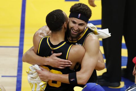 Golden State Warriors guard Klay Thompson, right, hugs Stephen Curry after the Warriors defeated the Dallas Mavericks in Game 5 of the NBA basketball playoffs Western Conference finals in San Francisco, Thursday, May 26, 2022. The Warriors advanced to the NBA Finals. (AP Photo/John Hefti)