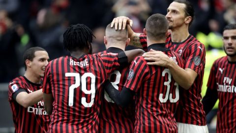 AC Milan's Ante Rebic, center, celebrates with his teammates after scoring his side's third goal during a Serie A soccer match between AC Milan and Udinese, at the San Siro stadium in Milan, Italy, Sunday, Jan. 19, 2020. (AP Photo/Luca Bruno)