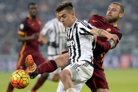 Juventus' Paulo Dybala, left, is challenged by Roma's Daniele De Rossi during a Serie A soccer match, at the Juventus stadium, in Turin, Italy, Sunday, Jan. 24, 2016. (AP Photo/Massimo Pinca)