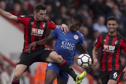 AFC Bournemouth's Lewis Cook, left, and Leicester City's Kelechi Iheanacho battle for the ball during the English Premier League soccer match between AFC Bournemouth and Leicester City at the Vitality Stadium, Bournemouth, England. Saturday, Sept, 30, 2017. (Simon Cooper/PA via AP)