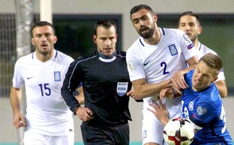 Greece's Ioannis Manniatis, center left, and Estonia's Karol Mets struggle for a ball during their World Cup Group H qualifying soccer match between Estonia and Greece in Tallinn, Estonia, on Tuesday, March 29, 2016. (AP Photo/Liis Treimann)