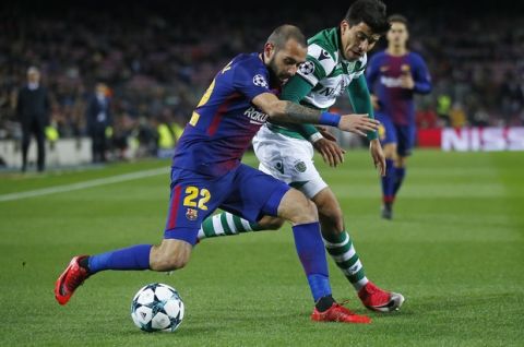 Barcelona's Aleix Vidal and Sporting's Marcos Acuna, from left, challenge for the ball during the Champions League Group D soccer match between FC Barcelona and Sporting CP at the Camp Nou stadium in Barcelona, Spain, Tuesday, Dec. 5, 2017. (AP Photo/Manu Fernandez)