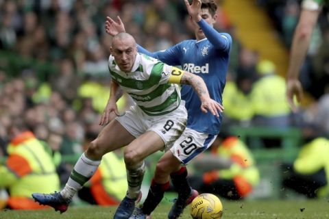 Celtic's Scott Brown, left, and Rangers' Emerson Hyndman battle for the ball during the Scottish Premiership soccer match at Celtic Park, Glasgow, Sunday March 12, 2017. (Jane Barlow/PA via AP)