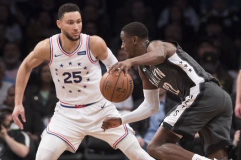 Brooklyn Nets guard Caris LeVert (22) drives against Philadelphia 76ers guard Ben Simmons (25) during the first half of of Game 4 of a first-round NBA basketball playoff series, Saturday, April 20, 2019, in New York. (AP Photo/Mary Altaffer)