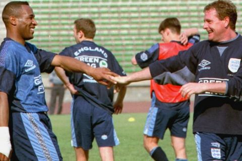 Les Ferdinand, left, and Paul Gascoigne share a joke as the English national soccer team practice  at the Beijing Workers' Stadium Thursday May 23 1996. England will play China in a friendly international later Thursday at the stadium. (AP Photo/Xinhua, Cheng Zhishan)