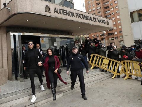 Cristiano Ronaldo leaves the court in Madrid with his girlfriend Georgina Rodriguez on Tuesday, Jan. 22, 2019. Cristiano Ronaldo is expected to plead guilty to tax fraud. The Juventus forward arrived in a black van, walked up some stairs leading to the court house and stopped to sign an autograph. The charges stem from his days at Real Madrid. (AP Photo/Manu Fernandez)