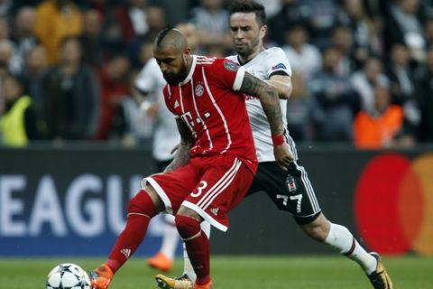 Bayern's Arturo Vidal, left, Besiktas' Gokhan Gonul challenge for the ball during the Champions League, round of 16, second leg, soccer match between Besiktas and Bayern Munich at Vodafone Arena stadium in Istanbul, Wednesday, March 14, 2018. (AP Photo/Lefteris Pitarakis)