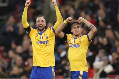 Juventus' Paulo Dybala, right, celebrates with his teammate Gonzalo Higuain after scoring his side second goal during the Champions League, round of 16, second-leg soccer match between Juventus and Tottenham Hotspur, at the Wembley Stadium in London, Wednesday, March 7, 2018. (AP Photo/Frank Augstein)