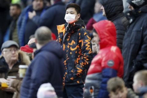 A spectator wears a face mask during the English Premier League soccer match between Burnley and Tottenham Hotspur at Turf Moor, Burnley, England, Saturday March 7, 2020. (Martin Rickett/PA via AP)