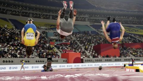 Armand Duplantis, left, of Sweden; Piotr Lisek, center, of Poland; and Sam Kendricks, right, of the United States; do flips after the the men's pole vault final at the World Athletics Championships in Doha, Qatar, Tuesday, Oct. 1, 2019. (AP Photo/Hassan Ammar)