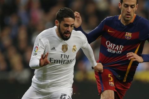 Real Madrid's Isco, left, duels for the ball with Barcelona's Sergio Busquetsduring the first clasico of the season between Real Madrid and Barcelona at the Santiago Bernabeu stadium in Madrid, Spain, Saturday, Nov. 21, 2015. (AP Photo/Daniel Ochoa de Olza)